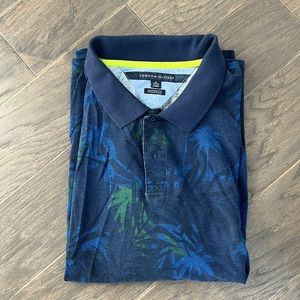 Short sleeve patterned polo with palm trees in green and blue.